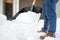 A mature man clean path near house from snow during strong blizzard. Person shoveling snow out of the driveway. Huge snowdrifts.