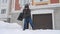 A mature man clean path near house from snow during strong blizzard. Person shoveling snow out of the driveway. Huge snowdrifts. D