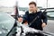 A mature man cleans his car with a brush after a snowfall. Snowdrift after a snowstorm on the hood of the automobile