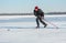 Mature man desperately trying to catch up the pack while playing hockey on a frozen river Dnepr in Ukraine