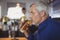 Mature man drinking a glass of beer at counter