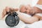 Mature man extending hand to alarm clock in bed