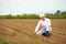 Mature man, farmer on arable field, checking the plant growth