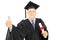 Mature man in graduation gown holding a diploma and giving thumb