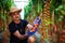 Mature man in hat check the red cherry tomatoes harvest in greenhouse family business