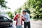 A mature man helping a young woman to walk after a car accident.