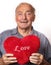 Mature man holding a red heart