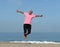 Mature man jumping on beach