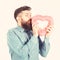 Mature man with long beard holds pink valentine heart.