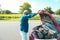 Mature man with a mask breaks down his car while traveling