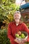 Mature Man Picking Apples From Tree In Garden