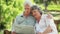 Mature man reading a newspaper while embracing his wife