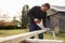 Mature Man Sawing Wood Outdoors