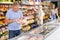 Mature man shopping in supermarket, choosing frozen convenience food