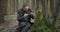 Mature man sitting on ground and examining green moss