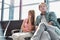 Mature man sitting with his daughter while waiting for their flight in airport