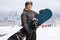 Mature man with snowboard posing at a ski resort