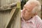 Mature man spying round a wooden door