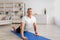 Mature man stretching back muscles, doing sphinx cobra pose or upward-facing dog asana, empty space