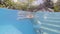 Mature man swimming crawl stroke in outdoor floating pool in summer resort hotel. Underwater view senior man swimming in