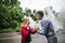 A mature man talking to a stressed young woman after a car accident.