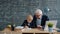 Mature man teacher teaching little smart boy in college classroom busy with education