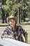 Mature man wearing cowboy hat leaning on wooden slab