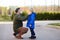 Mature man wearing a protective mask puts a face mask on a his son in airport, supermarket or other public place. Safety during