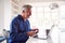 Mature Man In Wheelchair Looking Up Information About Medication Online Using Laptop