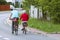 Mature man and woman rides a bicycle among the greens. A healthy and active part of life. Ecological transport for the population.