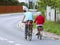 Mature man and woman rides a bicycle among the greens. A healthy and active part of life. Ecological transport for the population.