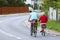 Mature man and woman rides a bicycle among the greens. A healthy and active part of life. Ecological transport for the population.