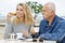 Mature man and young woman drinking coffee on beachside terrace