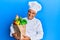 Mature middle east man professional chef holding bag of groceries looking positive and happy standing and smiling with a confident