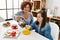 Mature mother and down syndrome daughter having coffee and lunch at home