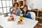 Mature mother and down syndrome daughter having coffee and lunch at home