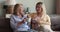 Mature mother grownup daughter sit on sofa chat drink tea