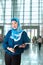 Mature Muslim woman with a book in exhibition hall