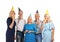 Mature people in birthday party hats with whistles on white background