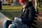 Mature person without home, money and work sitting on bench on street