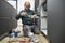 Mature plumber applying glue to a sink siphon white plastic pipe.