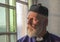 Mature priest looking out of a church window