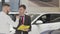 Mature salesman helping male customer choosing automobile to buy
