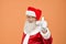 Mature Santa Claus in white gloves showing thumb up