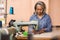 Mature seamstress working on a sewing machine in her workshop
