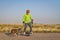 Mature senior male is riding one-wheeled electric skateboard  with a dog