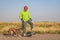 Mature senior male is riding one-wheeled electric skateboard  with a dog