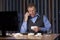 Mature sick man working at home at his desk with white handkerchiefs