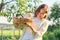 Mature smiling happy woman holding ginger kitten in basket