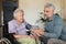 Mature son measuring blod pressure to her senior mother in her home.